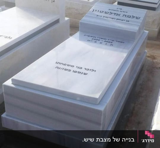 מצבת שיש לבן מוגמרת עם כיתוב שחור בבית עלמין